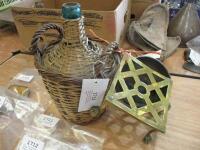 Wicker clad bottle together with a small bowl and a brass kettle stand