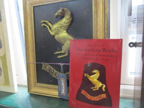 The Story of The Invicta Works by Michael R. Lane, a signed and dedicated copy to his son, together with the framed brass Invicta horse and scroll used on the front cover. By family repute it was direct from the factory, where it was on display.