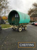 Bowtop Romany caravan fitted with canvas roof, mounted on pneumatic tyres, sprung axles, finished in green with embellishments