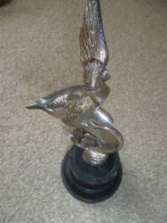 Mascot in the form of a winged goddess astride a winged wheel, nickel plate finish and plinth mounted