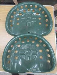 A pair of tin tractor/implement seats