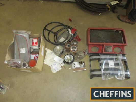 A tractor restorers lot comprising NOS parts, cables, lights, grilles, steering wheel etc.